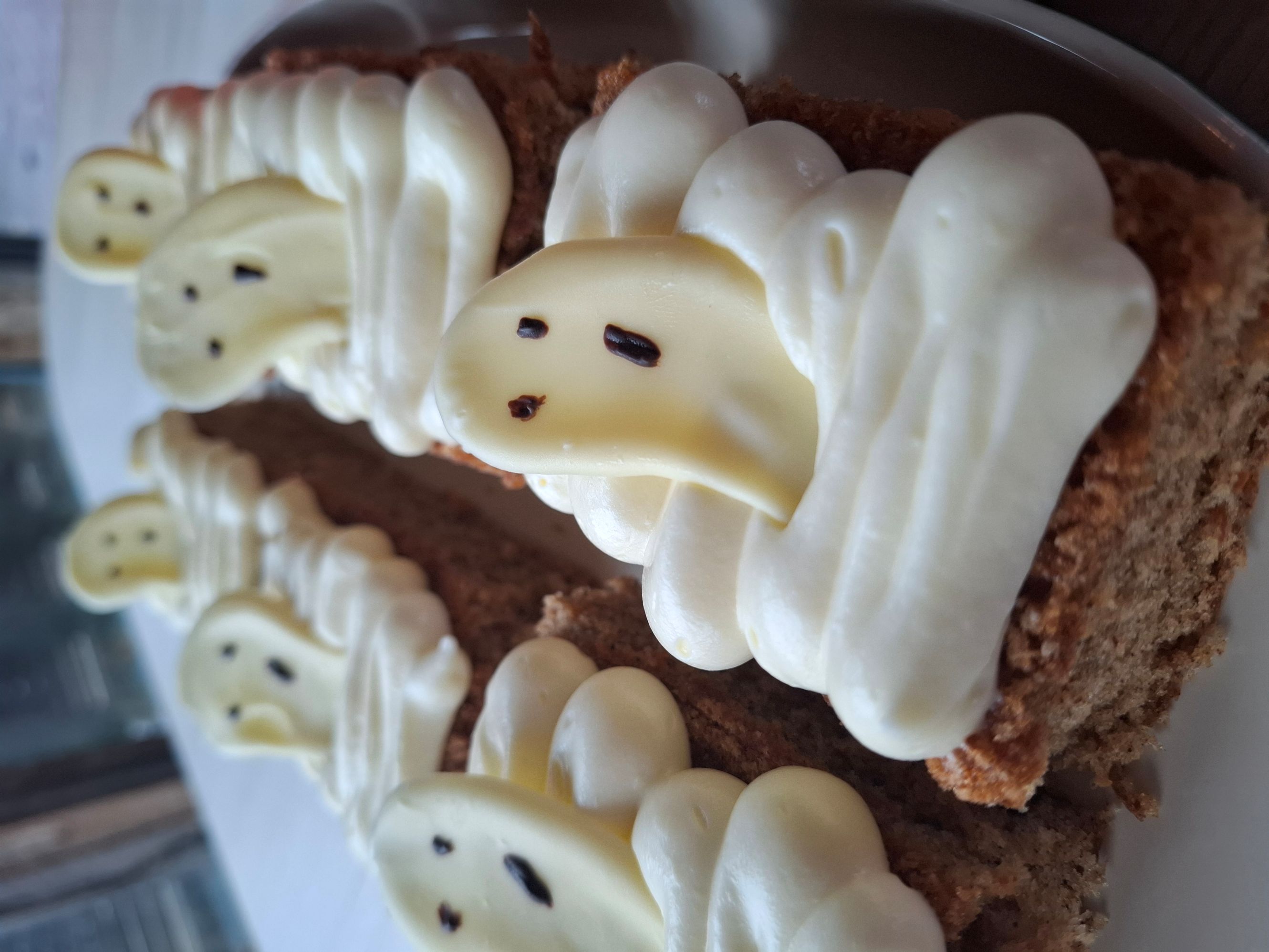 Mjuk kaka med krämig topping och spökdekoration.